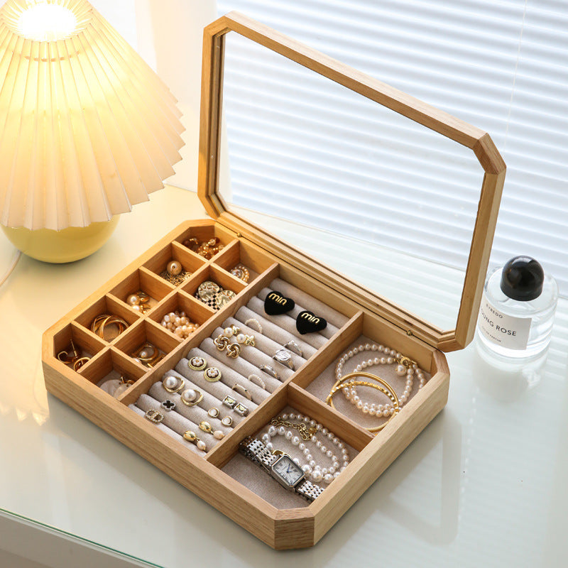 Front view of oak octagonal jewelry box with glass lid in ambient room lighting
