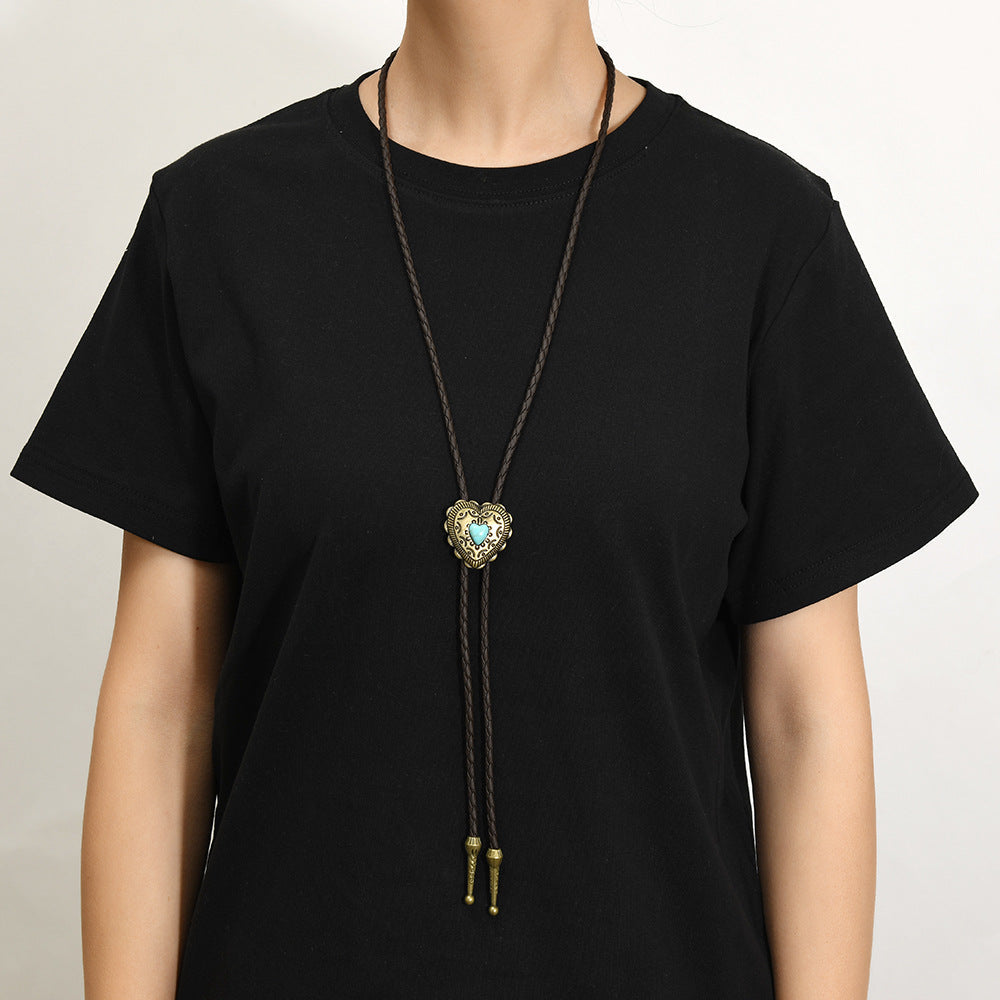 Side profile detail shot of turquoise heart pendant with braided deep coffee leather and antique bronze finish