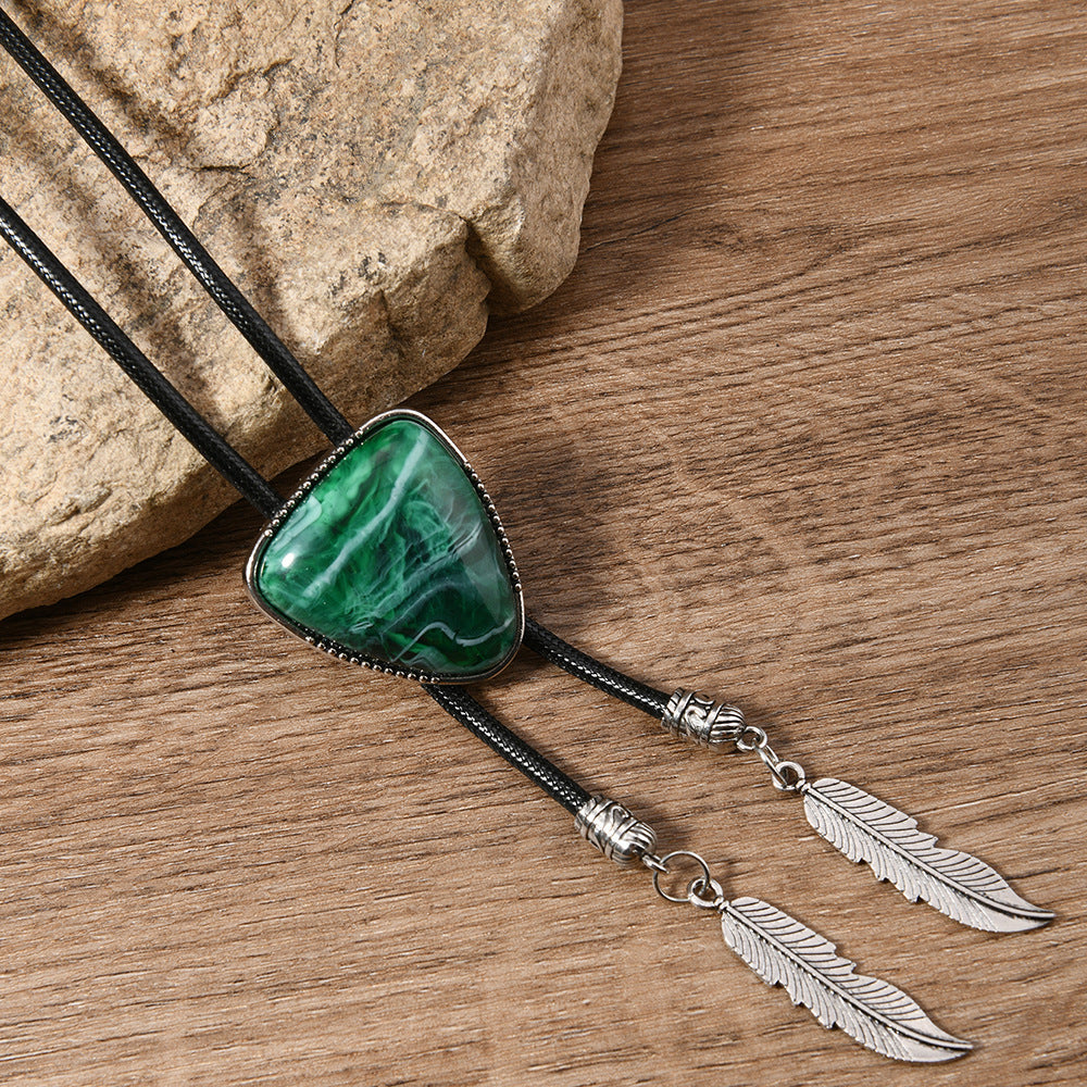 Side profile close-up of black alloy triangle pendant necklace highlighting crystal inlay detail