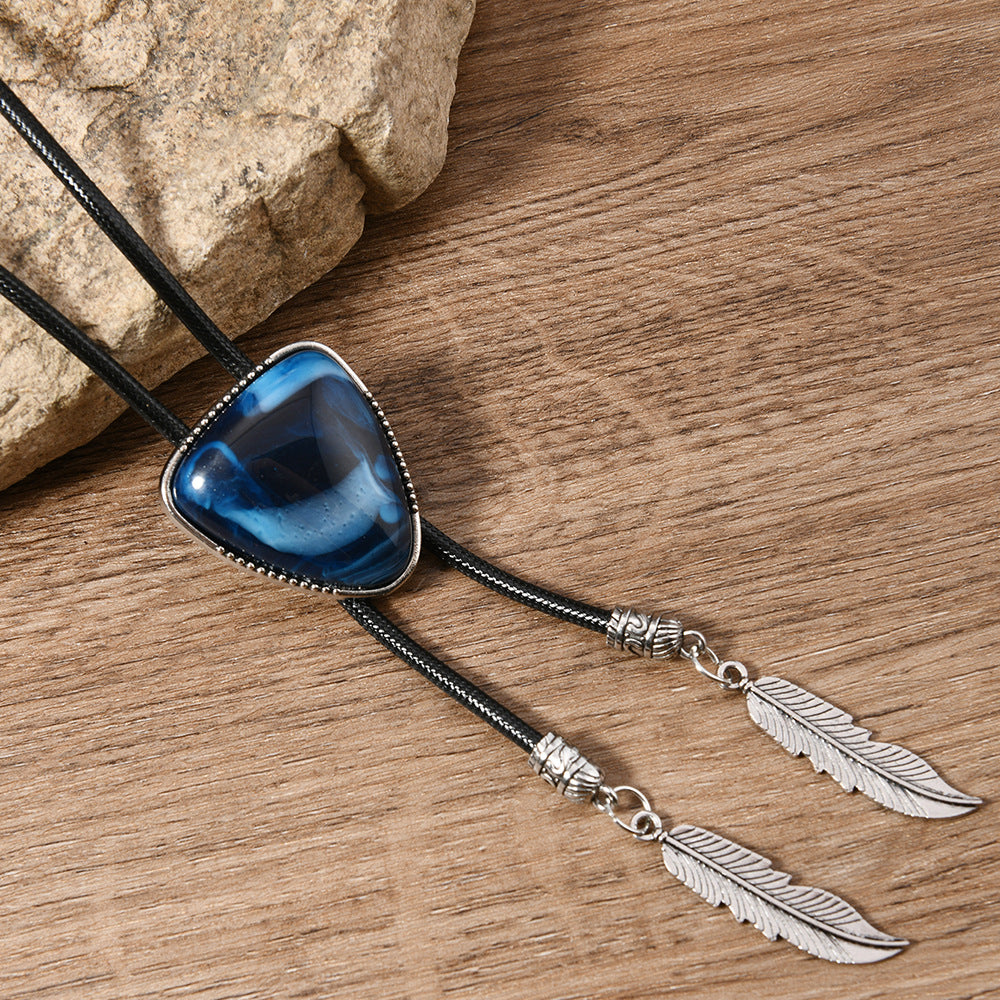 Top-down view of black triangle crystal inlay pendant necklace with visible standard chain detail