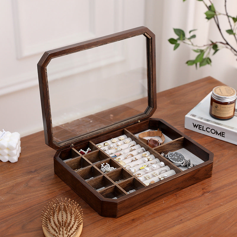 Front view of black walnut octagonal jewelry box with glass lid in ambient room lighting